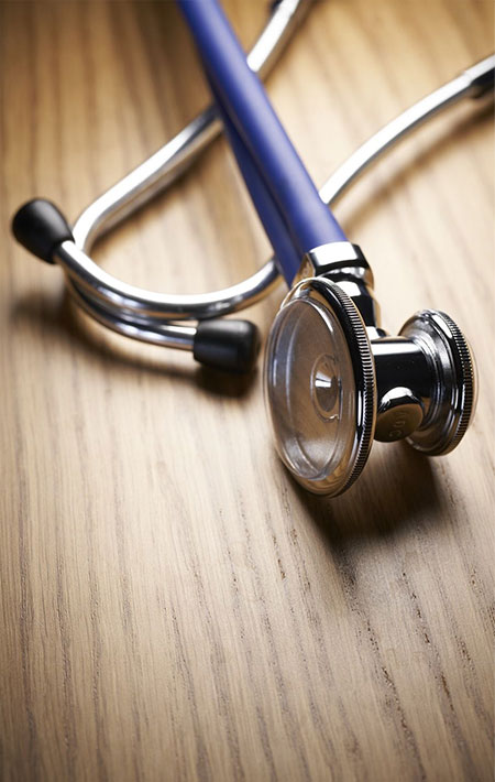 A close-up photo of a stethoscope on a wooden surface.